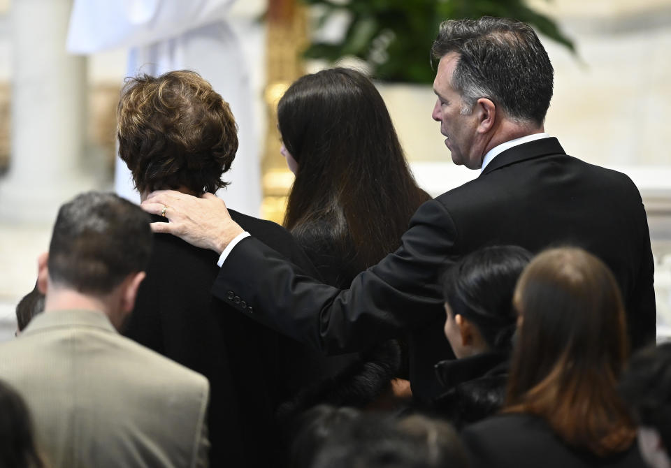 From left, Brian Fraser's mother, Mary 'Mia' sister, Micaela, and father, Sean, watch as Brian's casket proceeds into the church as family members friends and supporters gather during the funeral mass for Fraser at St Paul on the Lake Catholic Church, in Grosse Pointe Farms, Mich., Saturday, Feb. 18, 2023. Fraser was identified as one of three students slain during a mass shooting on Michigan State University's campus, Monday evening. (Todd McInturf/Detroit News via AP, Pool)