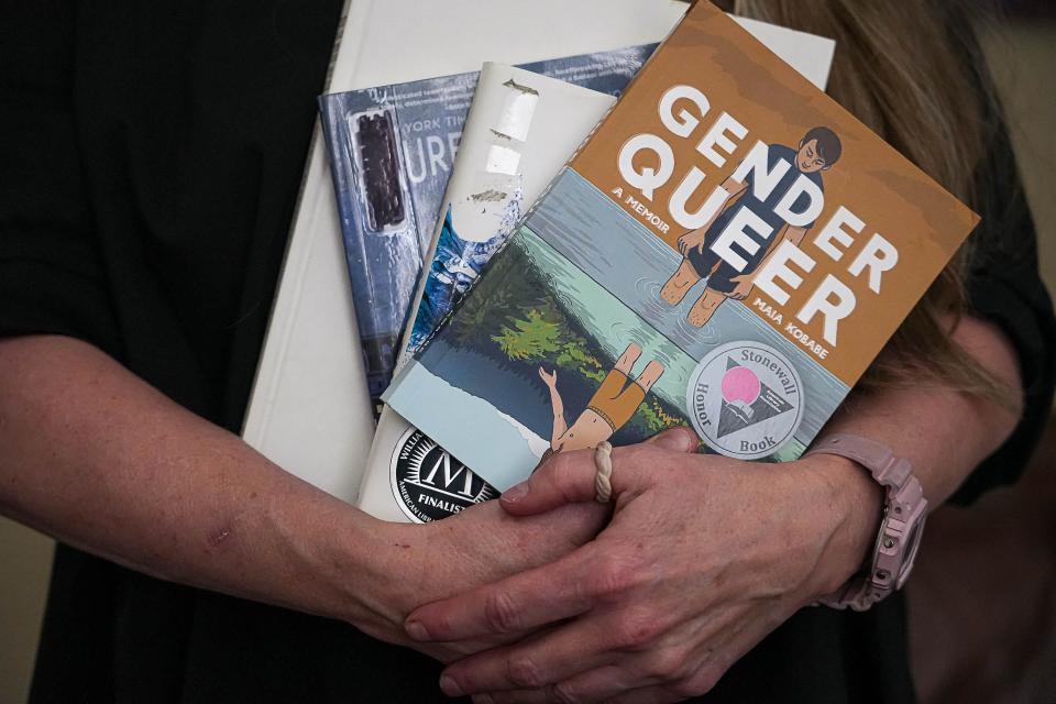Suzette Baker holds some banned books at the Edwards Law office in Austin on Monday.