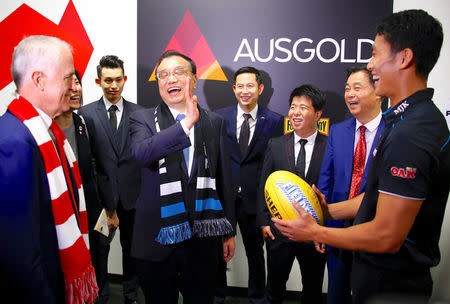 FILE PHOTO - Australia's Prime Minister Malcolm Turnbull watches Chinese Premier Li Keqiang laugh with Port Adelaide player Chen Shaoliang (R), the Australian Rules football club's international academy recruit from China, during a visit to the team's room before the start of an Australian Football League (AFL) game at the Sydney Cricket Ground (SCG) in Australia, March 25, 2017. REUTERS/David Gray/File photo