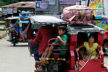 Residents ride on tricycles as they leave a residential neighbourhood Marawi City due to fighting between government soldiers and the Maute militant group, in southern Philippines May 27, 2017. REUTERS/Erik De Castro