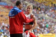 <p>Ashton Eaton of United States speaks with his wife Brianne Theisen Eaton of Canada on winning silver after the heptahlon during Day Four of the 14th IAAF World Athletics Championships Moscow 2013 at Luzhniki Stadium on August 13, 2013 in Moscow, Russia. (Photo by Getty Images) </p>