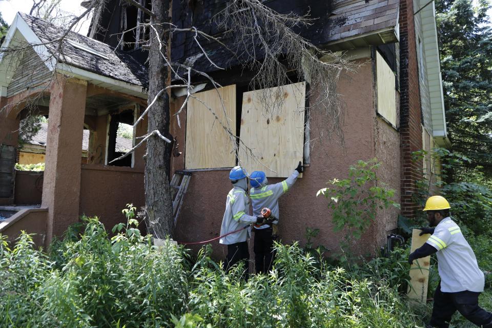 FILE - In this June 11, 2019 file photo, members of the Detroit's Board Up Brigade board up a vacant home in north Detroit. Murder charges could be announced against man suspected of killing at least four women and stowing their bodies in vacant houses in Detroit. Wayne County Prosecutor Kym Worthy is expected Wednesday, Sept. 18, to discuss the case against 34-year-old Deangelo Martin.(AP Photo/Carlos Osorio, File)