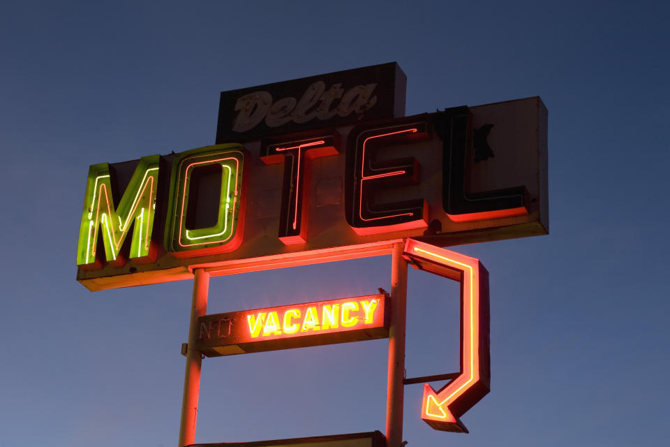 Neon sign for Delta Motel at dusk, with a lit "NO VACANCY" notice
