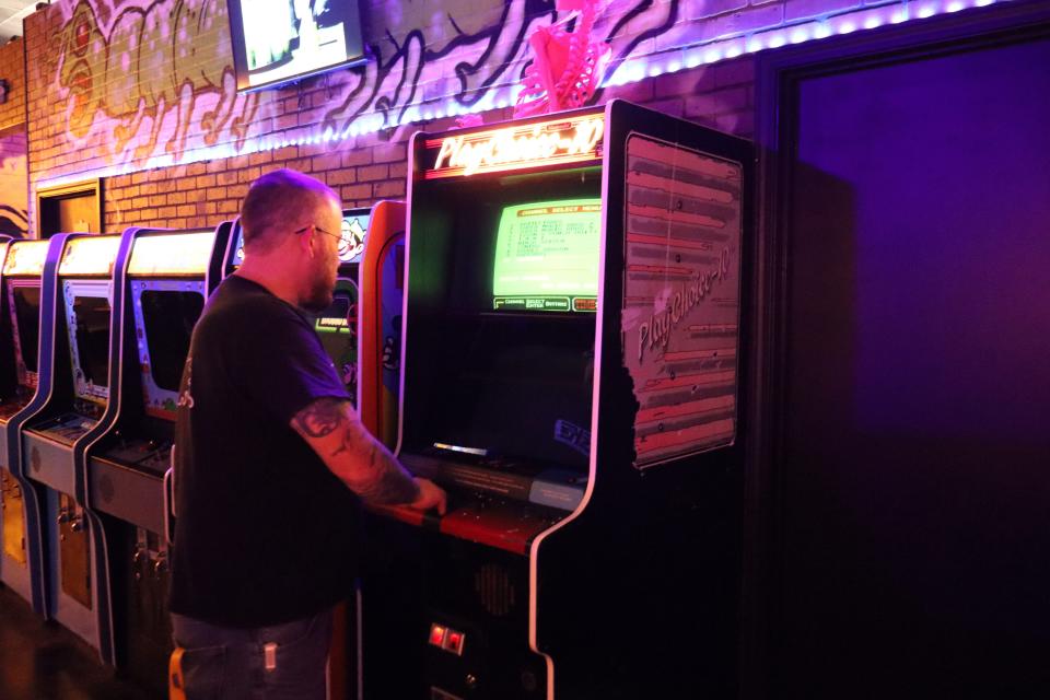 Evan Paul, one of the co-owners of Wayback's Arcade in Pineville, checks out a PlayChoice-10 that's one of 150 arcade games available for players.