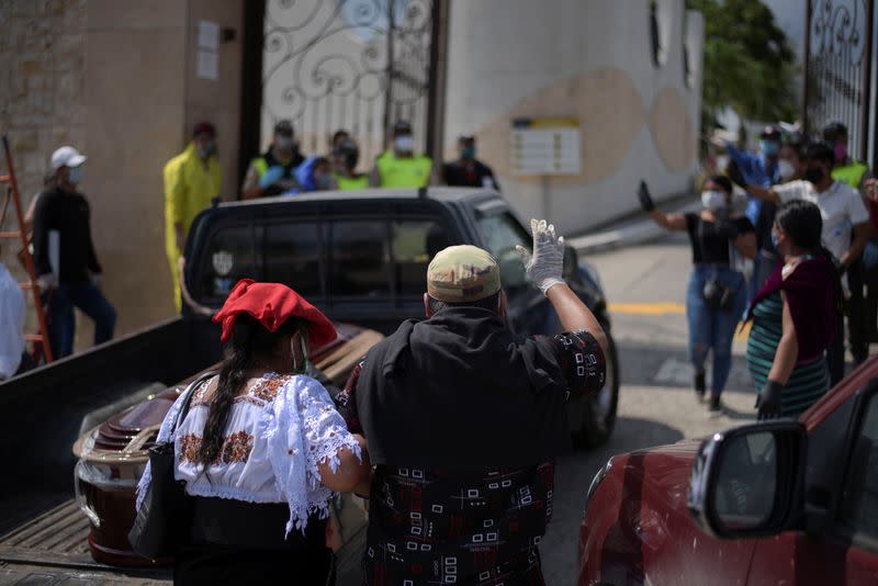 Mourners wave to a coffin in a pick-up truck entering a cemetery as Ecuador's government announced on Thursday it was building a "special camp" in Guayaquil for coronavirus disease (COVID-19) victims, in Guayaquil