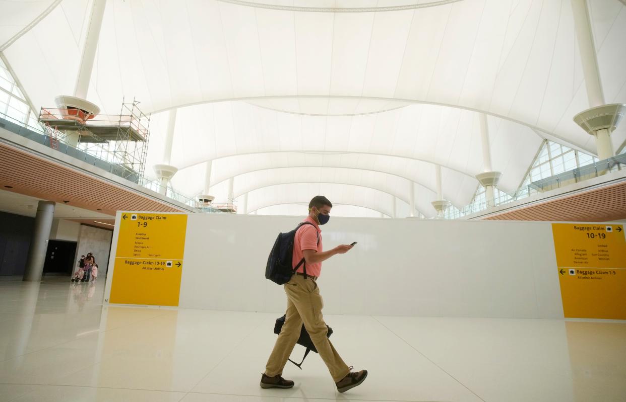 A passenger walks through the Denver International Airport, which like others has seen a major drop in traffic due to Covid-19. (Copyright 2021 The Associated Press. All rights reserved.)