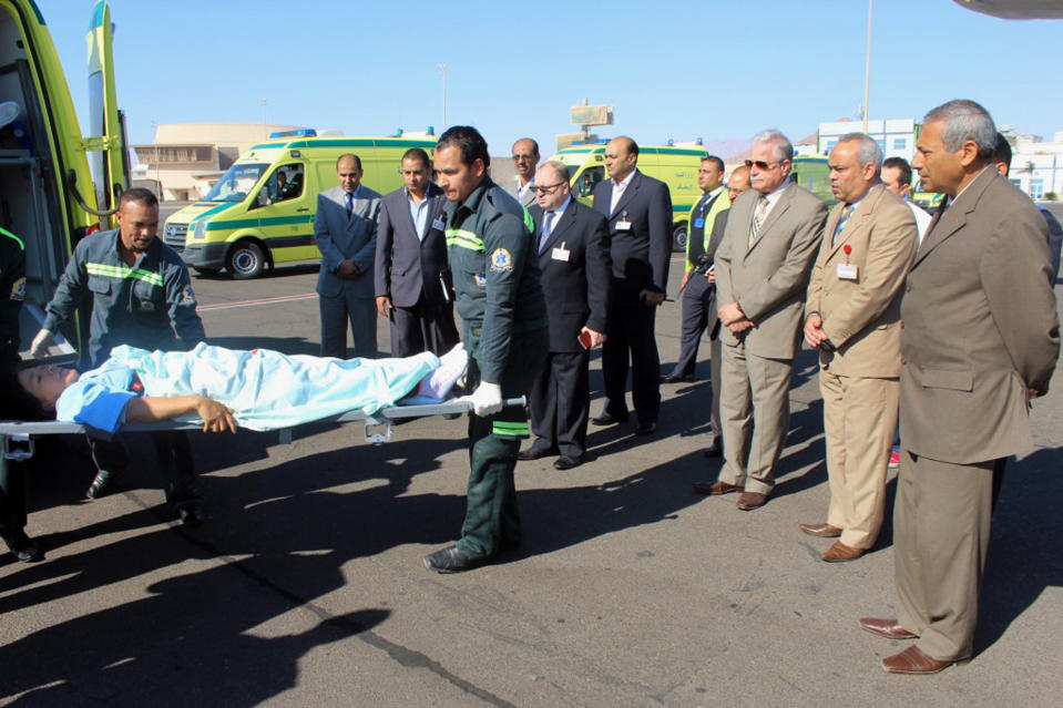 In this photo released by the Office of the South Sinai Governor, the Governor of South Sinai, Major General Khaled Foda, third right, and other officials watch as a South Korean tourist who was wounded in a deadly blast Sunday, on a bus in Taba, is evacuated to her home country, at Sharm el Sheikh airport, Egypt, Wednesday, Feb. 19, 2014. The bombing Sunday was the first targeting foreign tourists in the Sinai in nearly decade, raising fears that Islamic militants who have been waging a campaign of violence against security forces in the peninsula are now turning to attack tourism, a pillar of Egypt's economy. (AP Photo/Office of the South Sinai Governor)