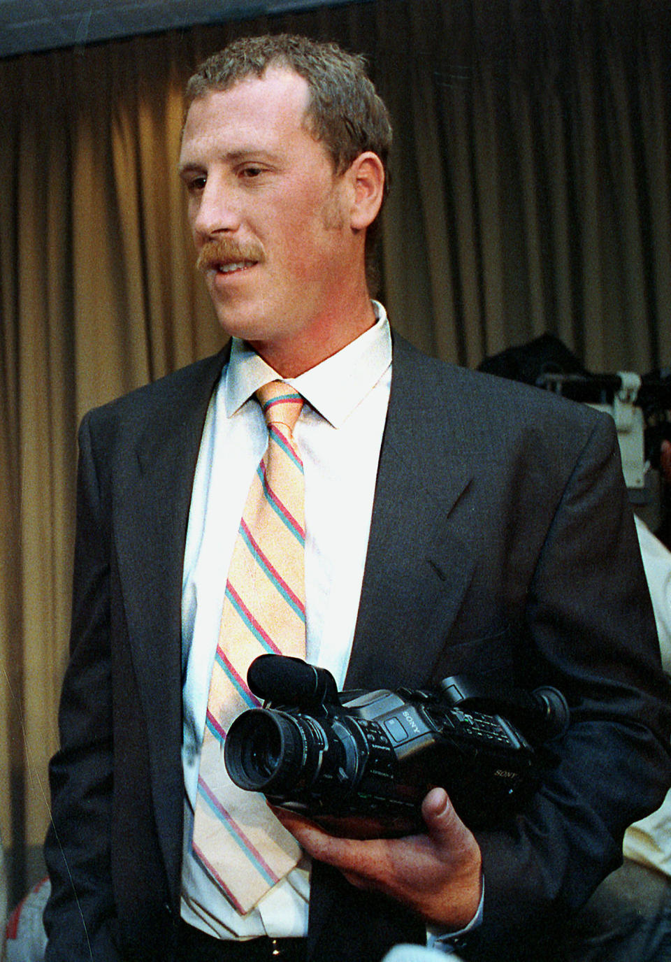 FILE - In this March 28, 1991, file photo, George Holliday, the man who videotaped the beating of Black motorist Rodney King by four Los Angeles Police Department officers, holds his camera after a news conference, in Los Angeles. Holliday has died from COVID-19, it was reported Monday, Sept. 20, 2021. (AP Photo/Craig Fujii, File)