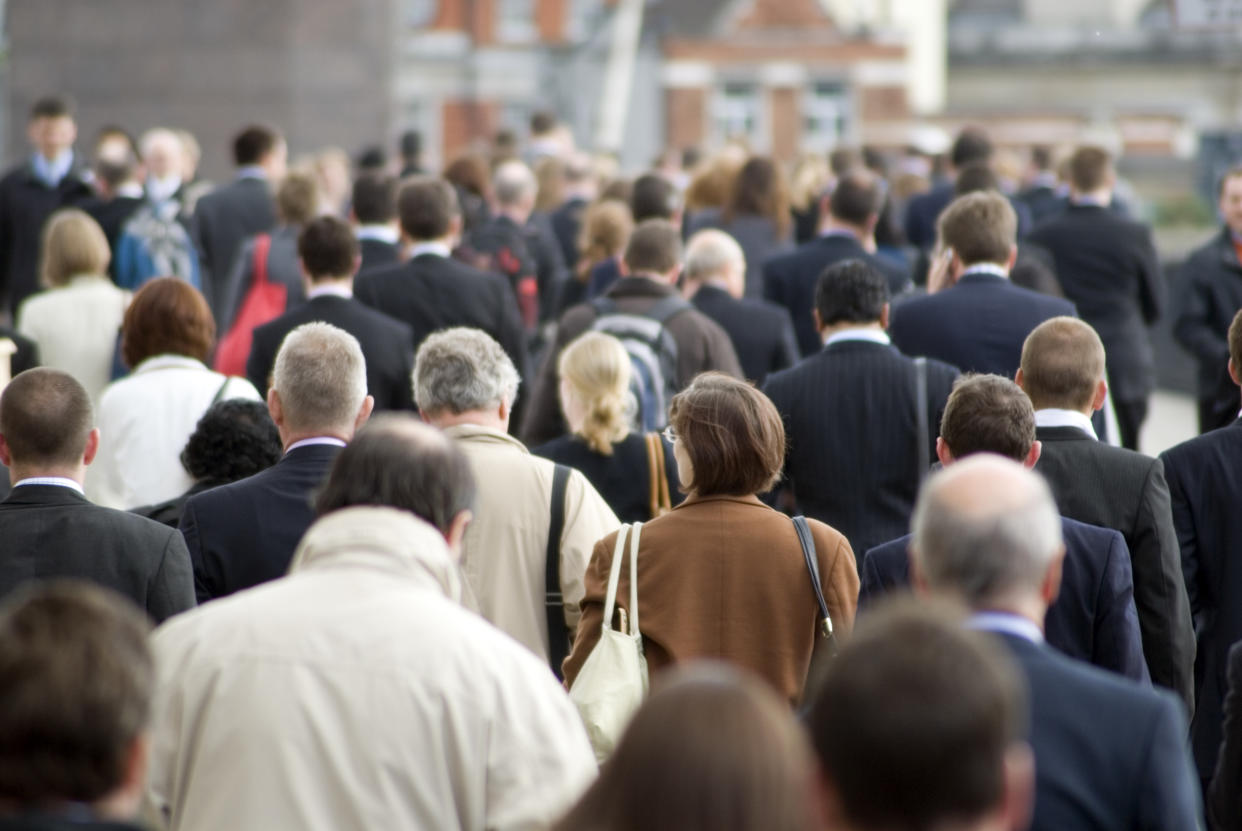 Office workers walking across London Bridge on their way home from work during rush hour.