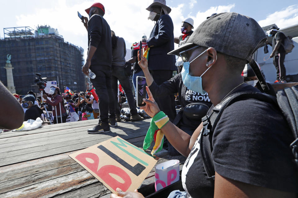 People record speakers and the crowd during a Caribbean-led Black Lives Matter rally at Brooklyn's Grand Army Plaza, Sunday, June 14, 2020, in New York. (AP Photo/Kathy Willens)