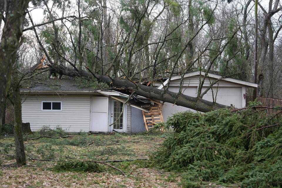 A tree sits on the garage of Dannie Devol on Stoneybrook Drive off Havens Corners Road after an EF2 tornado passed through the Blacklick area of Jefferson Township in eastern Franklin County Wednesday morning.