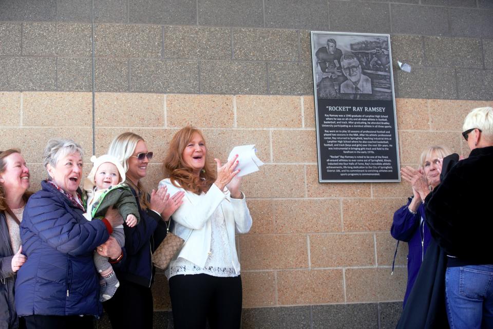 Chris Ramsey Broeker, middle left, celebrates with family after the plaque is unveiled at Memorial Stadium during a ceremony naming the track area after her dad, Ray Ramsey, on Saturday, April 20, 2024. Her sisters Lisa, Cheri and Cathy were also present.