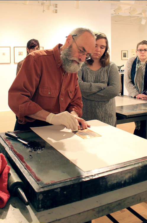 The late Marc St. Pierre, a printmaking professor, preparing an etching plate at the opening reception for "E is for Elephants, The Etchings of Edward Gorey" (2014).