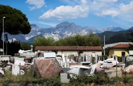 The Apuan Alps are seen in the background of a marble dealer warehouse in Carrara, Tuscany, Italy, July 15, 2017. REUTERS/Alessandro Bianchi