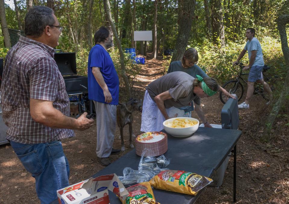 Residents of a homeless camp in Toms River share a mid-day Friday afternoon meal. Although the normally eat separately a communal meal happens a few times a month.