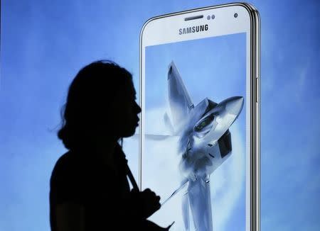 A woman walks past an advertisement promoting Samsung Electronics' Galaxy S5 smartphone in Seoul July 29, 2014. REUTERS/Kim Hong-Ji