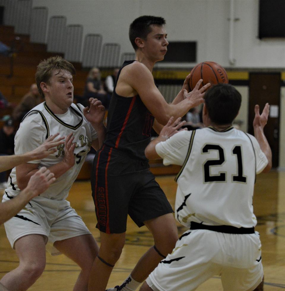 Morgan's Rowdy Williams makes a pass against River View's Brody Shrimplin and Laired Williamson in Friday's game. The Raiders won 58-47.