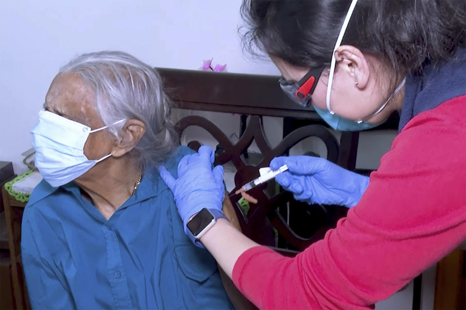 Dr. Won Lee gives a COVID-19 vaccine to Domingas Pina at home in Boston, Feb. 9, 2021. Millions of U.S. residents will need COVID-19 vaccines brought to them because they rarely or never leave home. Doctors and nurses who specialize in home care are leading this push and starting to get help from state and local governments around the country. Pina hasn’t left home in about a year. (AP Photo/Rodrique Ngowi)