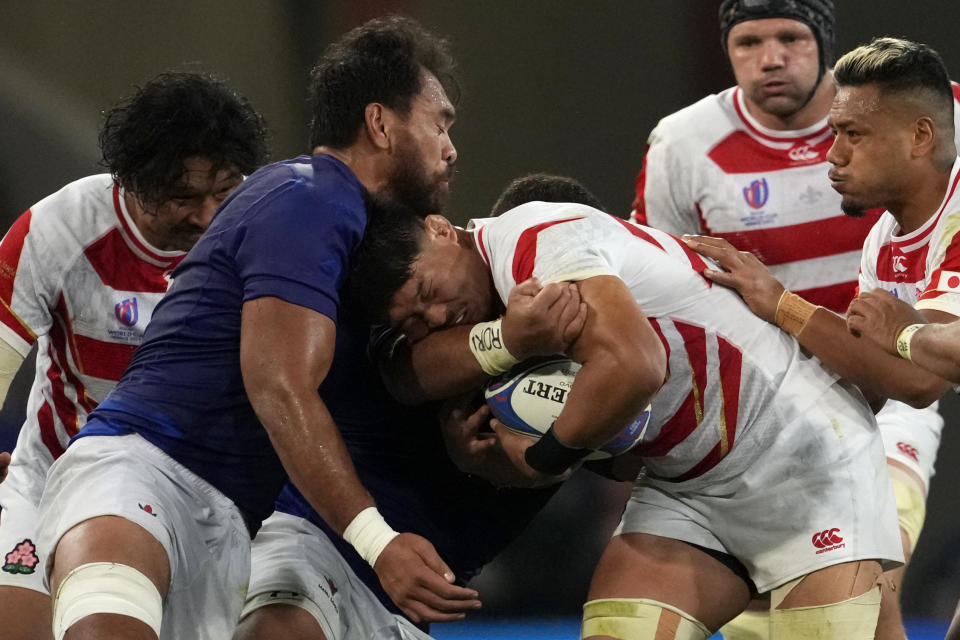 Japan's captain Kazuki Himeno is tackled by Samoa's Steven Luatua during the Rugby World Cup Pool D match between Japan and Samoa, at the Stadium de Toulouse in Toulouse, France, Thursday, Sept. 28, 2023. (AP Photo/Christophe Ena)