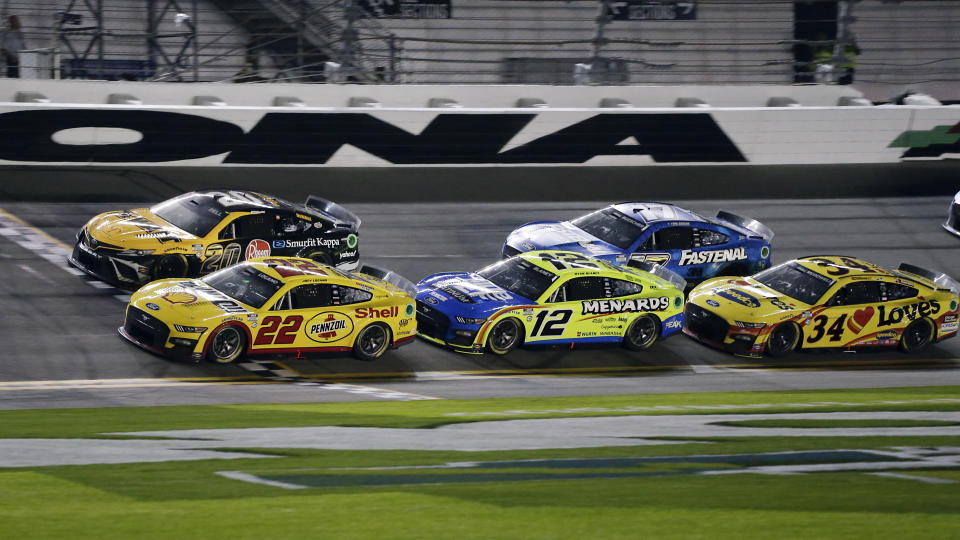 Joey Logano (22) crosses the finish line ahead of Christopher Bell (20), Ryan Blaney (12), Chris Buescher (17) and Michael McDowell (34) to win the first of two qualifying auto races for the NASCAR Daytona 500 at Daytona International Speedway, Thursday, Feb. 16, 2023, in Daytona Beach, Fla.(AP Photo/Terry Renna)