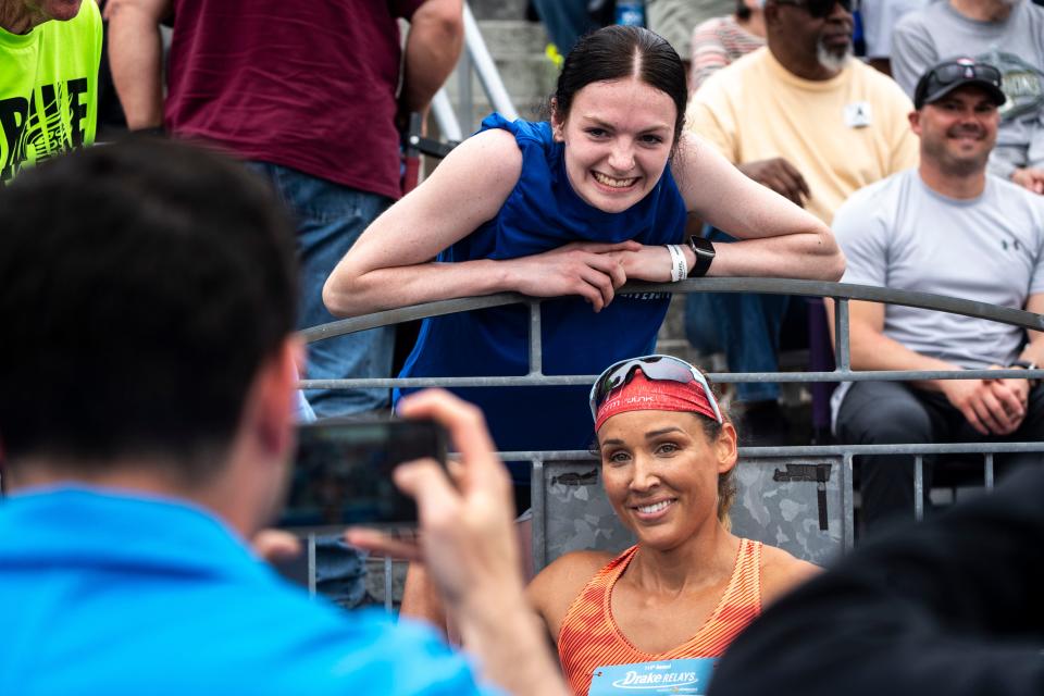 Lolo Jones takes a photo with a fan the World Athletic Continental Tour 100 meter hurdle race during the Drake Relays at Drake Stadium on Saturday.