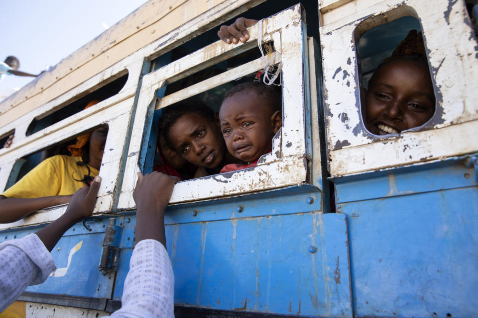 Refugees who fled the conflict in Ethiopia's Tigray region ride a bus going to the Village 8 temporary shelter, near the Sudan-Ethiopia border, in Hamdayet, eastern Sudan. (Nariman El-Mofty/AP)