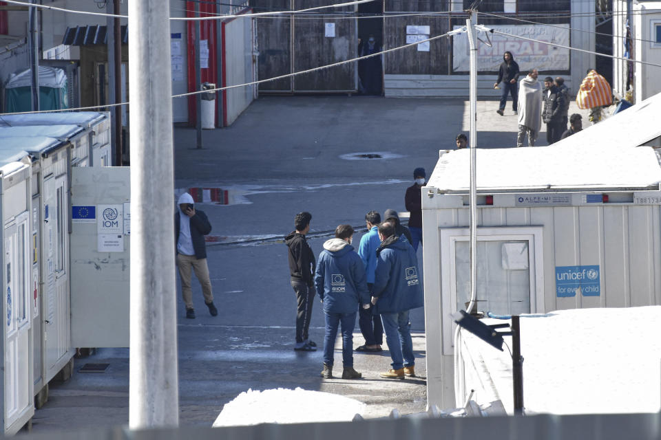 Migrants walk inside the Miral camp, in Velika Kladusa, Bosnia, Wednesday, April 7, 2021. Bosnia is seeing a rise in coronavirus infections among migrants and refugees living in its camps, as it struggles to cope with one of the Balkans' highest COVID-19 death and infection rates among the general population.(AP Photo/Davor Midzic)