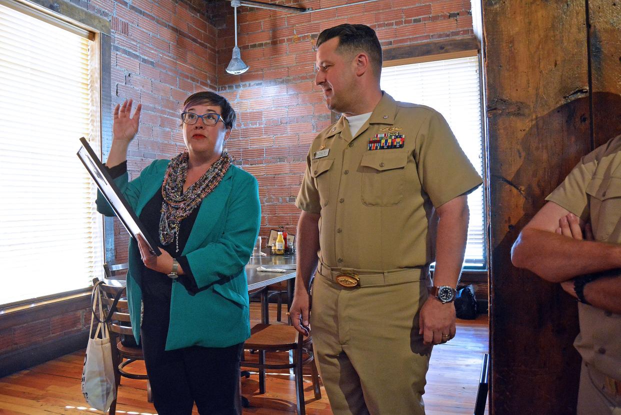 Columbia Mayor Barbara Buffaloe while presenting a proclamation Wednesday to USS Columbia Cmdr. Brad Foster at Flat Branch Pub and Brewing notes the submarine's and the restaurant's joint 30-year history.