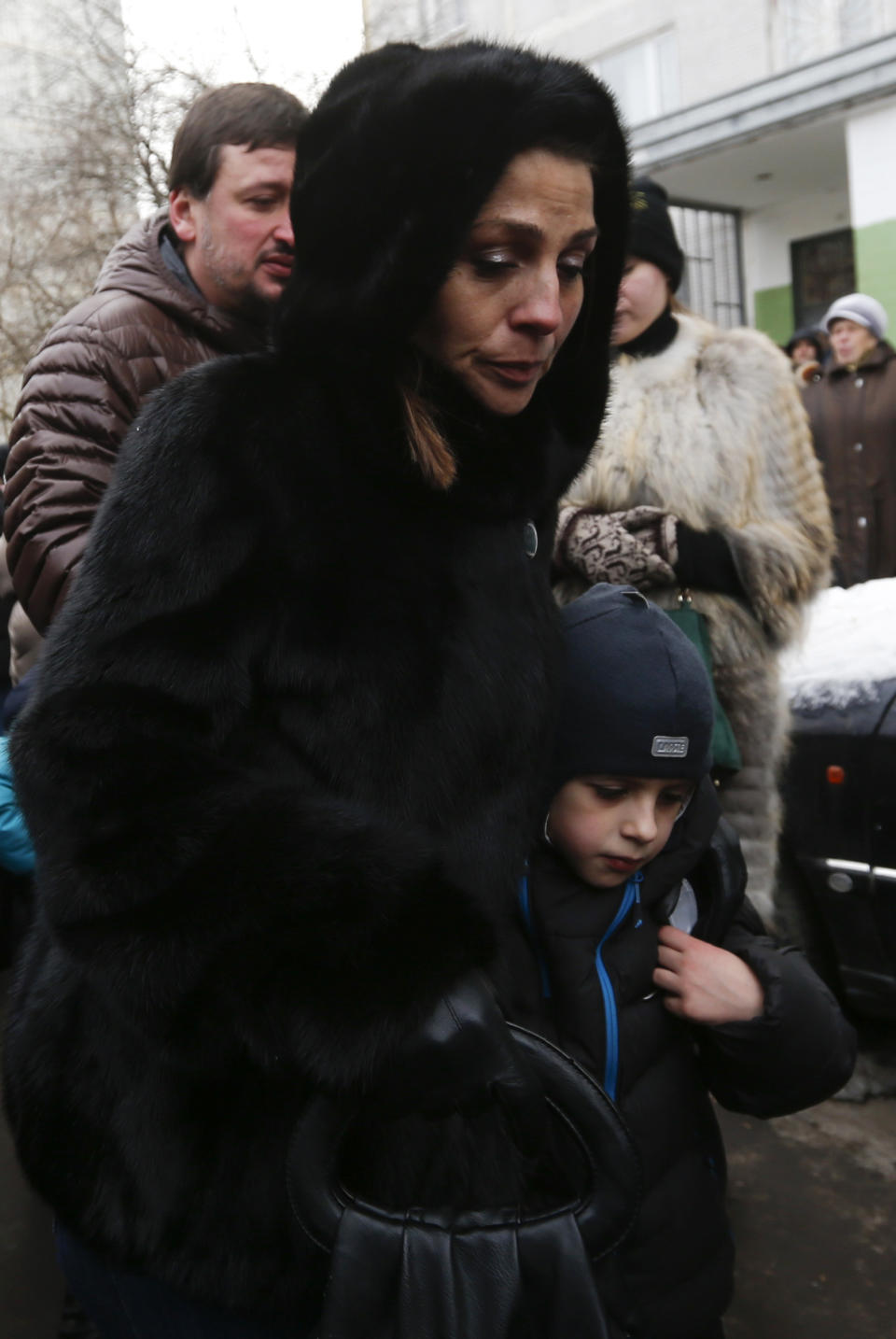 A woman and child walk outside the premises of a high school, where a shooting incident has occurred, on the outskirts of Moscow, February 3, 2014. A Moscow high-school student shot a teacher and a police officer dead and held more than 20 other students hostage in a classroom on Monday before he was disarmed and detained, police said, just days before Russia hosts the Winter Olympics. (REUTERS/Maxim Shemetov)