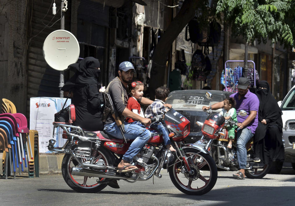 In this Monday, Sept. 10, 2018 photo, family members ride their motorcycles in the centre of the northern city of Idlib, Syria. Syrian government forces, backed by Russia and Iran, have been massing troops for weeks in preparation for an attack on Idlib province, the last major rebel stronghold in the country. The U.N. has warned that a battle will spark a humanitarian catastrophe, where more than 3 million people live in the territory, nearly half of them already displaced from fighting elsewhere in Syria. (Ugur Can/DHA via AP)