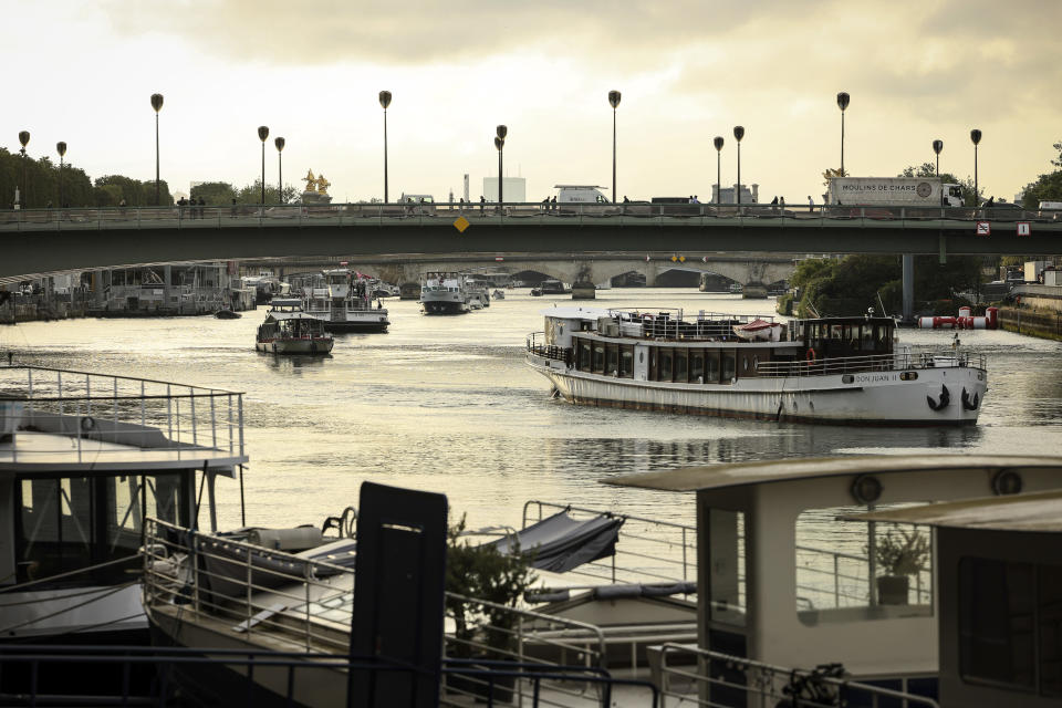 Barges cruise on the Seine river during a rehearsal for the Paris 2024 Olympic Games opening ceremony, Monday, June. 17, 2024 in Paris. The river will host the Paris 2024 Olympic Games opening ceremony on July 26 with boats for each national delegation. (AP Photo/Thomas Padilla)