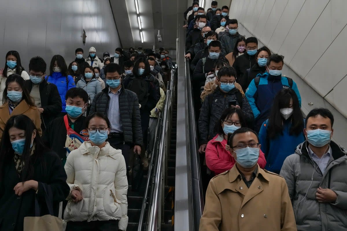 Commuters rush to catch their trains at a subway station during the morning rush hour in Beijing (AP)