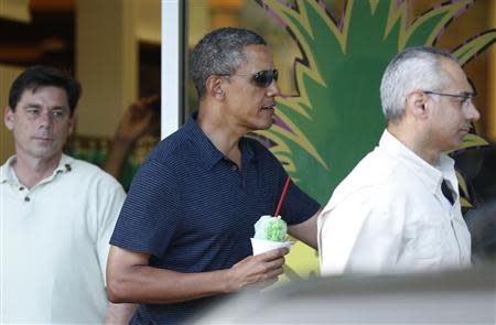 Flanked by Secret Service personnel, U.S. President Barack Obama carries a shave ice out of Island Snow near his vacation home in Kailua, Hawaii December 31, 2013. REUTERS/Kevin Lamarque