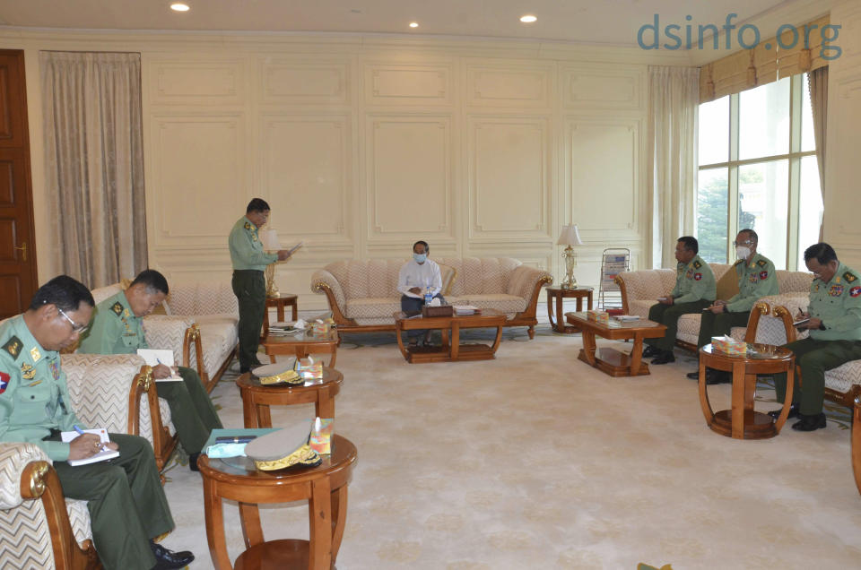 In this photo released by The Military True News Information Team, Myanmar Acting President Myint Swe, center, military chief Senior Gen. Min Aung Hlaing, standing at left, and other military members of National Defence and Security Council attend a meeting at Presidential Palace in Naypyitaw, Myanmar Monday, Feb. 1, 2021. (The Military True News Information Team via AP)