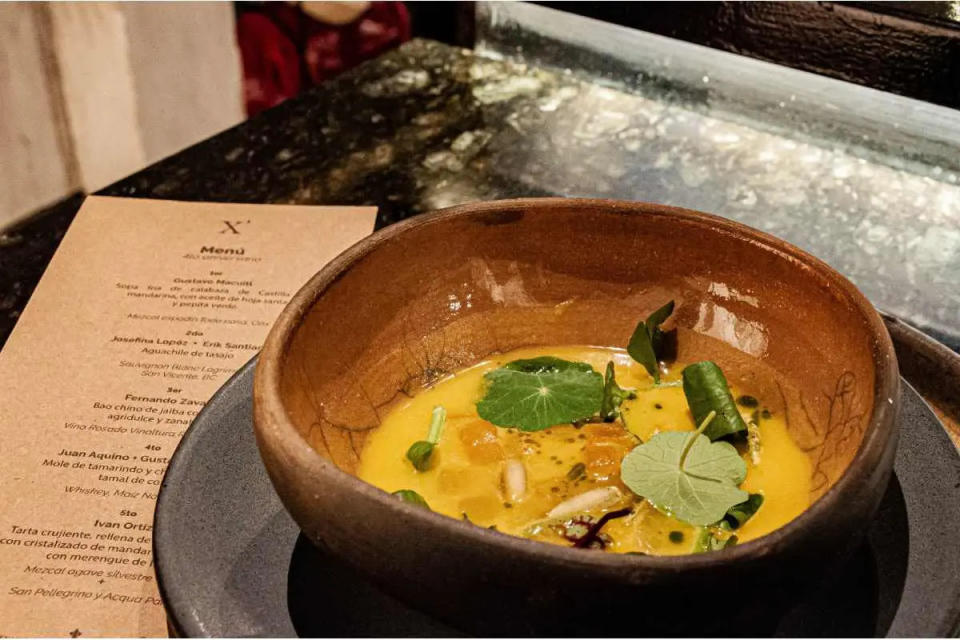 Para el 1er tiempo se eligió una sopa fría de calabaza de castilla y mandarina con aceite de hoja santa y pepita verde, a cargo del chef Gustavo Macuitl, originario de San Jerónimo Tecuanipan, Puebla.