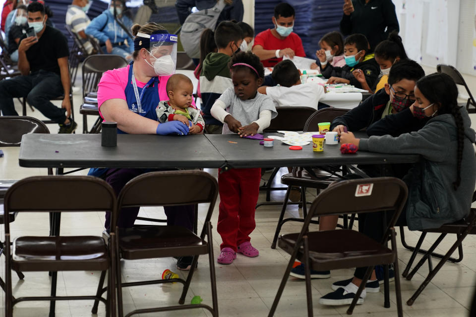 Migrants pass the time at a migrant shelter, Wednesday, May 12, 2021, in McAllen, Texas. The U.S. government continues to report large numbers of migrants crossing the U.S.-Mexico border with an increase in adult crossers. But families and unaccompanied children are still arriving in dramatic numbers despite the weather changing in the Rio Grande Valley registering hotter days and nights. (AP Photo/Gregory Bull)