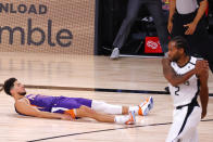 Phoenix Suns' Devin Booker falls to the ground after scoring the game-winning basket against the Los Angeles Clippers in an NBA basketball game Tuesday, Aug. 4, 2020, in Lake Buena Vista, Fla. (Kevin C. Cox/Pool Photo via AP)