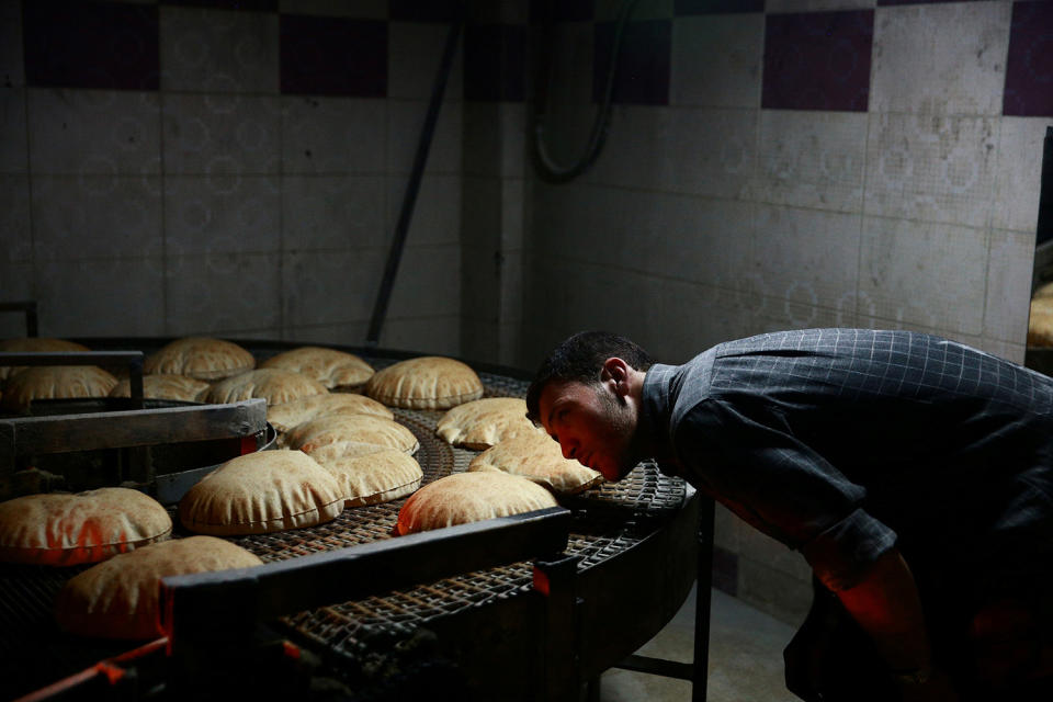 Man inspects line of bread