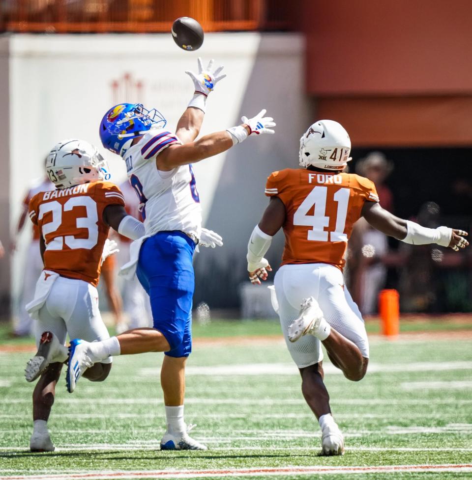 Texas football defensive back Jahdae Barron (23) and linebacker Jaylan Ford (41) chase Kansas tight end Mason Fairchild (89) as he reaches for a catch during a game on Sept. 30 this year at Darrell K Royal-Texas Memorial Stadium in Austin.