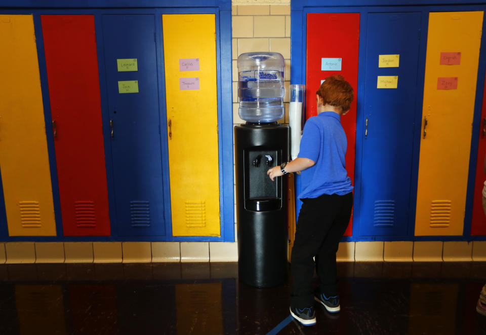FILE- In this Sept. 4, 2018 file photo, a student gets water from a cooler in the hallway at Gardner Elementary School in Detroit. Some 50,000 Detroit public school students will started the school year by drinking water from coolers, not fountains, after the discovery of elevated levels of lead or copper. New Jersey's biggest city has recently been the epicenter of a problem with lead in drinking water, but the United States has an estimated 6 million lead pipes, many of them in unknown locations. (AP Photo/Paul Sancya, File)