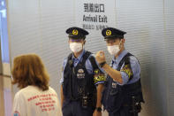 Police officers stand guard at international arrival exit at the Haneda International Airport Tuesday, Oct. 11, 2022, in Tokyo. Japan's strict border restrictions are eased, allowing tourists to easily enter for the first time since the start of the COVID-19 pandemic. Independent tourists are again welcomed, not just those traveling with authorized groups. (AP Photo/Eugene Hoshiko)