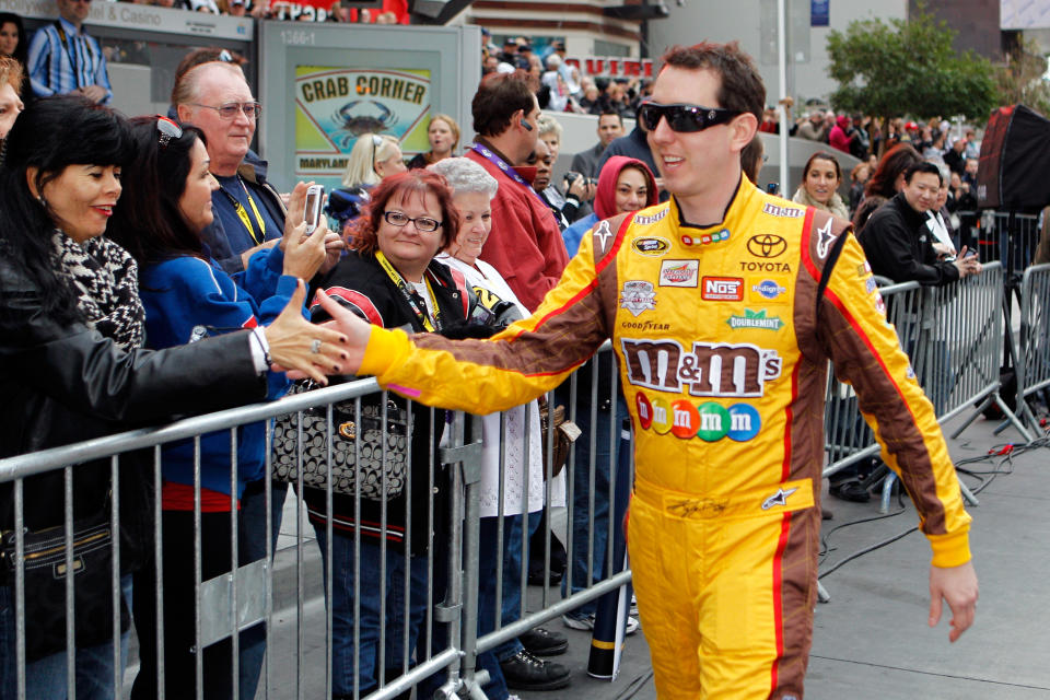 LAS VEGAS, NV - DECEMBER 01: Kyle Busch, driver of the #18 Interstate Batteries Toyota, greets fans before the NASCAR Victory Lap on the Las Vegas Strip on December 1, 2011 in Las Vegas, Nevada. (Photo by Chris Graythen/Getty Images for NASCAR)