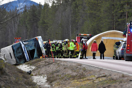 Rescue workers are seen at the site where a bus carrying school children and adults rolled over on a road close to the town of Sveg, in northern Sweden April 2, 2017. TT News Agency/Nisse Schmidt/via REUTERS