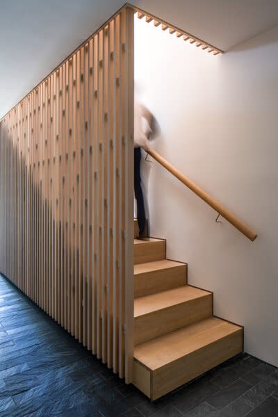 The entryway's stairs are surrounded by a screen that helps diffuse sunlight.