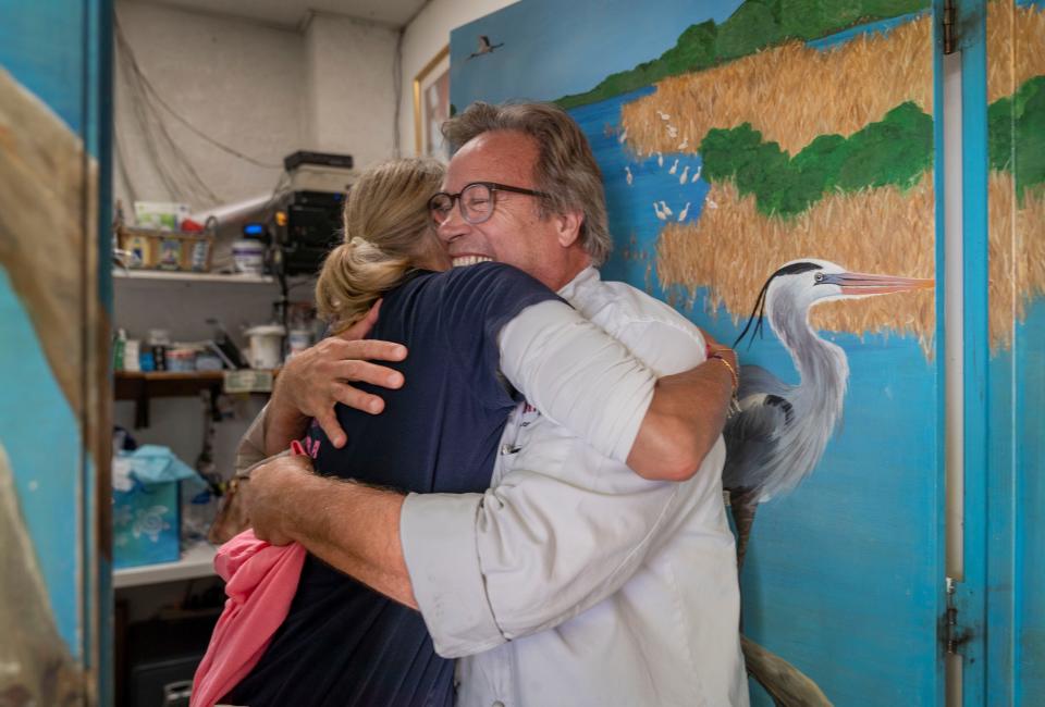 Jennifer Wilson gets a hug from customer Alain Bedard at Duke's Lazy Loggerhead Cafe in Jupiter, Florida on August 10, 2022. 