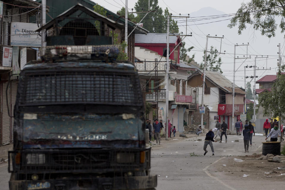 Kashmir protesters throw stones and bricks at an armored vehicle of Indian police during a protest near the site of a gunbattle in Pulwama, south of Srinagar, Indian controlled Kashmir, Thursday, May 16, 2019. Three rebels, an army soldier and a civilian were killed early Thursday during a gunbattle in disputed Kashmir that triggered anti-India protests and clashes, officials and residents said. (AP Photo/ Dar Yasin)