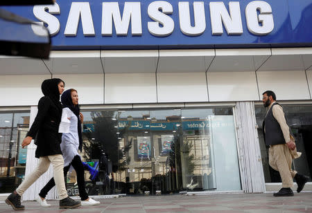 Afghans pass by in front of a Samsung shop in Kabul, Afghanistan July 1, 2018. REUTERS/Omar Sobhani/Files