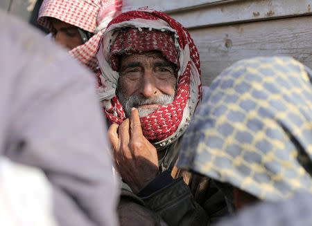 An elderly man sits at the back of a bus near Baghouz, Deir Al Zor province, Syria February 11, 2019. REUTERS/Rodi Said