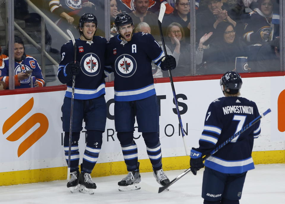 Winnipeg Jets' Morgan Barron and Adam Lowry celebrate Lowry's goal against the Edmonton Oilers during second period of NHL hockey game in Winnipeg, Manitoba, Saturday, March 4, 2023. (John Woods/The Canadian Press via AP)