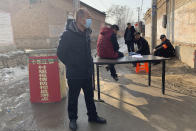 Men gather near a barricade on a road in Yinhuangying village in northern China's Hebei Province, Wednesday, Jan. 29, 2020. With barricades and wary guardians, villages on the outskirts of Beijing are closing themselves off to outsiders to ward against infection amid the outbreak of a new type of virus. (AP Photo)